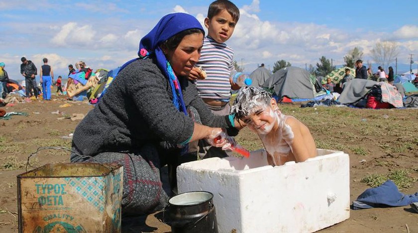 Συγκλονιστική φωτογραφία από την Ειδομένη: Προσφυγόπουλα κάνουν μπάνιο σε κουτί από φελιζόλ