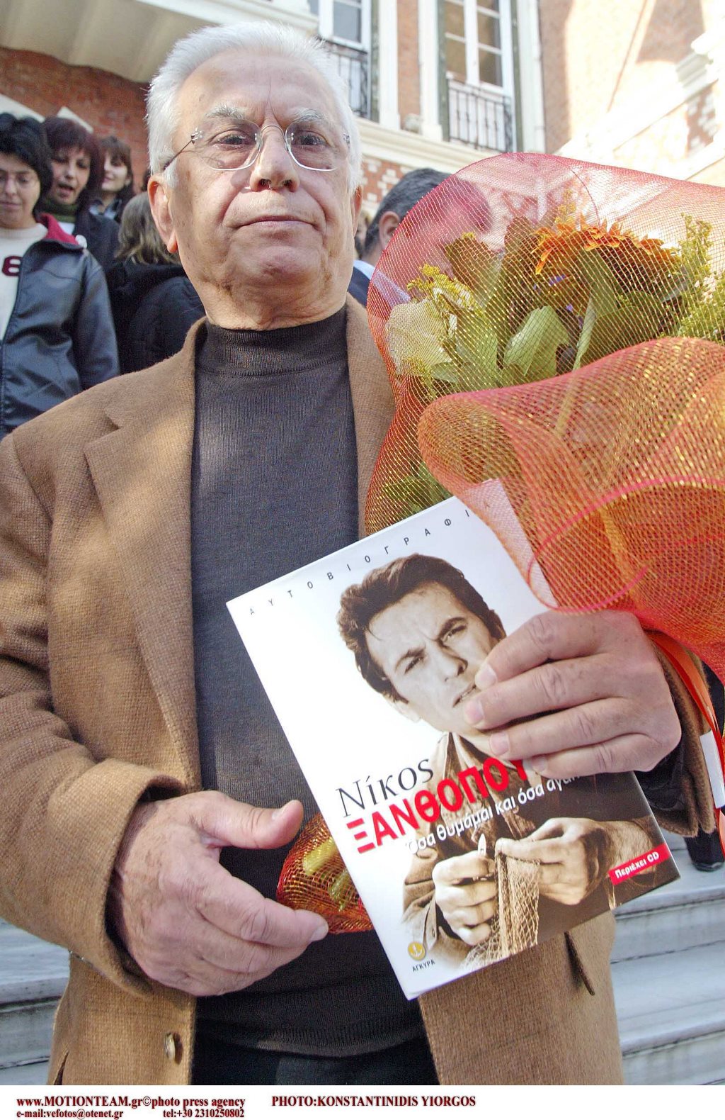 O Nίκος Ξανθόπουλος κρατώντας το βιβλίο με την αυτοβιογραφία του